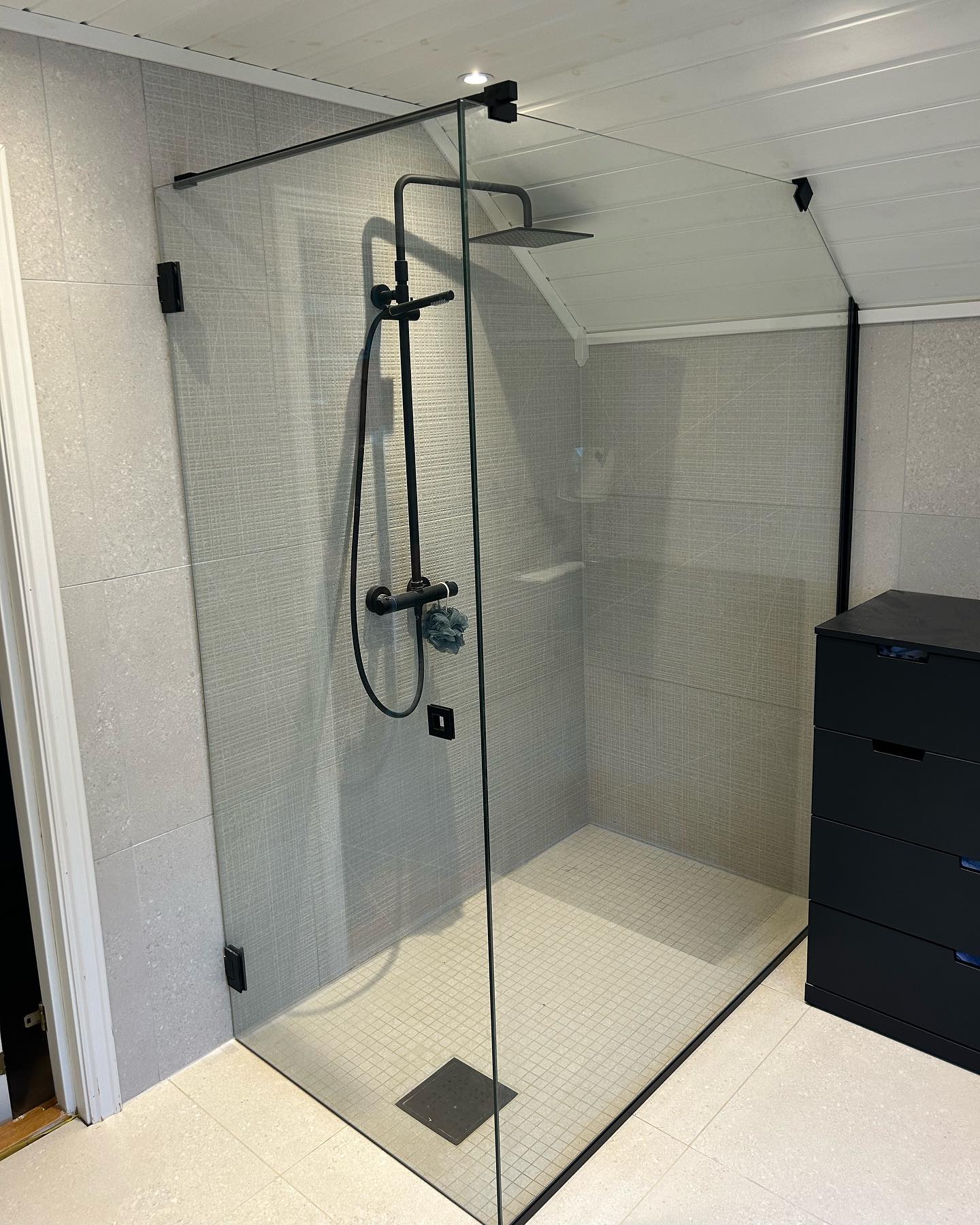 Moderne dusj med glassvegg og regndusj